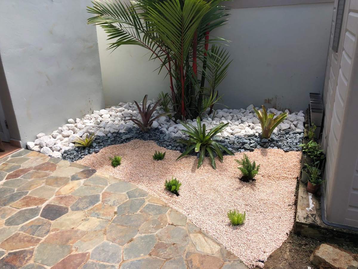 Después: patio terminado con piedra decorativa blanca, gris y rosada